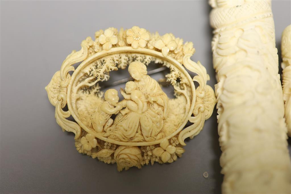 A 19th century carved ivory needlecase, length 15cm, and a brooch
